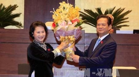 国会主席阮氏金银向阮晋勇先生赠送鲜花。（图片来源：越通社）