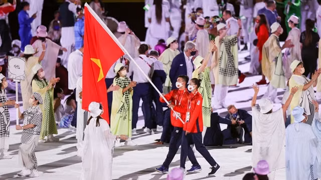 越南游泳选手阮辉煌和越南田径选手郭氏兰担任旗手