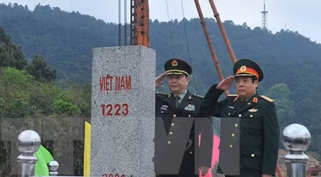 越中两国国防部长在越南谅山省禄平县芝麻口岸向1223号界碑敬礼。（图片来源：越通社）