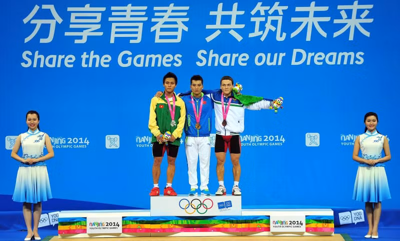 获得冠军的中国选手蒙成（中）、获得亚军的越南选手阮陈英俊（左二）和获得季军的乌兹别克选手阿德哈姆忠• 叶尔加舍夫在领奖台上。（图片来源：2014南京青奥会官方网站）