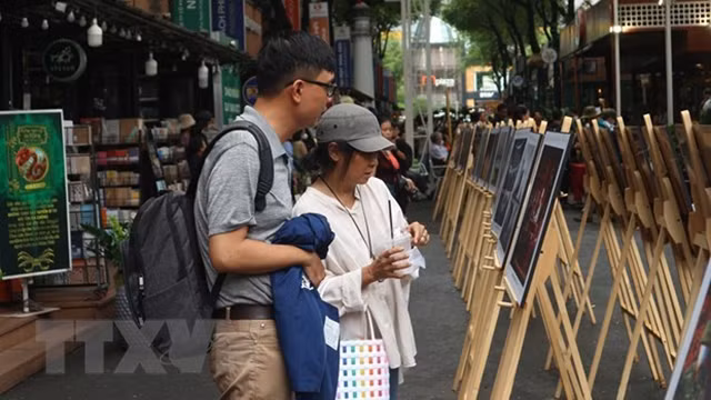 观众朋友观看《新冠肺炎疫情防控阻击战-印象深刻的时刻》新闻摄影展。