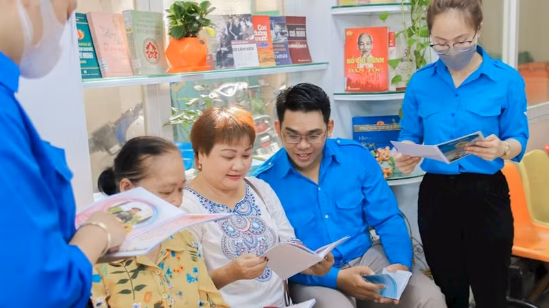 平盛郡青年向观众介绍有关胡志明主席的书籍。（图片来源：hcmcpv.org.vn）