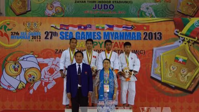 越南柔道选手黄一统（左二）在颁奖台上。（图片来源：越通社）