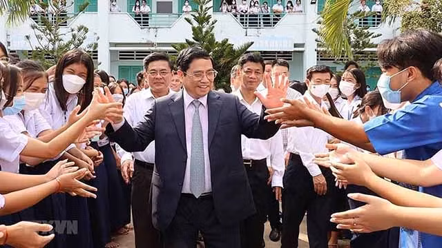 范明正总理与黄冈少数民族寄宿高中学校的学生。（图片来源：越通社）