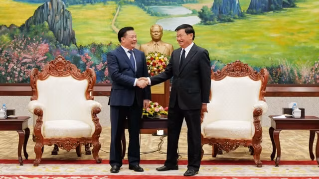 河内市委书记丁进勇与老挝人革党中央总书记、国家主席通伦•西苏里握手。