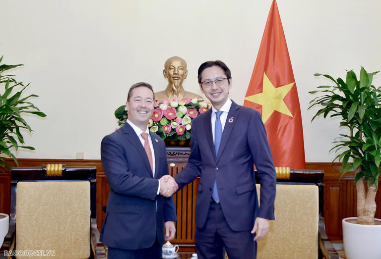 越南外交部副部长杜雄越与肖恩·小野·科塔罗现实握手。
