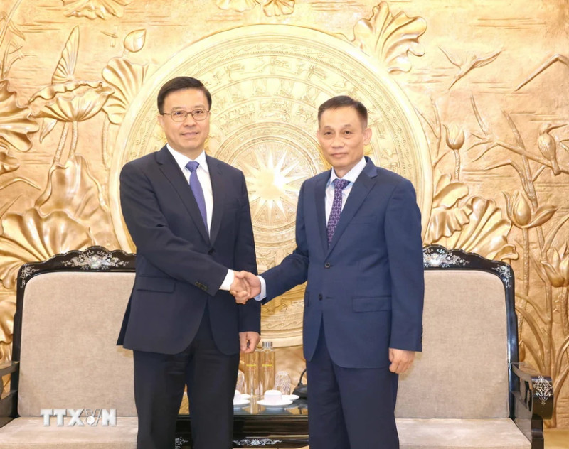 黎怀忠同志与赵世通同志握手。