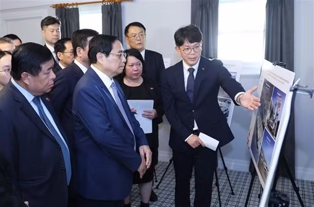 越南政府总理范明正参观韩国SK集团在澳大利亚的氢能项目模型。（图片来源：越通社）
