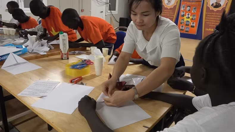 第三工程队队员指导小朋友利用回收材料制作玩具。 第三工程队队员指导小朋友利用回收材料制作玩具。