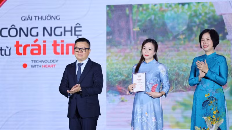 人民报社总编辑黎国明和越通社社长武越庄(右)颁发奖状。