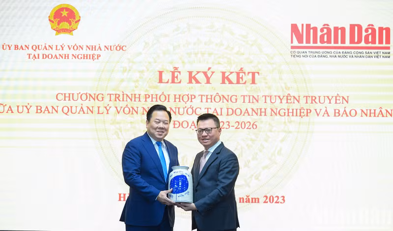 黎国明总编辑向阮黄英同志赠送纪念品。