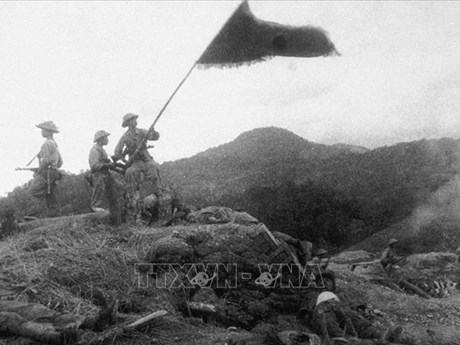 独立丘全景，1954年3月14日，在我军彻底摧毁欣蓝抵抗中心后，突击兵在敌军指挥掩体顶上高高举起胡志明主席的崇高奖项——决战决胜旗帜。（图片来源：越通社）