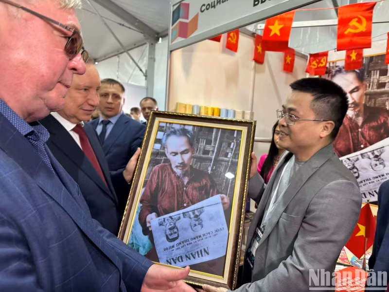 《人民报》社常驻俄罗斯记者代表《人民报》社领导集体向圣彼得堡市长赠送了”胡志明主席阅读《人民报》”照片。（春兴 摄）