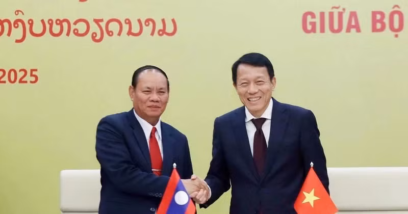 越共公安部部长梁三光大将和老挝公安部部长维莱·拉坎丰握手。