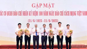 越南祖国阵线中央委员会主席杜文战与越共中央宣教与民运部常务副部长赖春门（左三、左四）在活动中向新闻机构领导代表赠送鲜花。