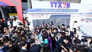 在2022年全国新闻展上，媒体记者报道关于越通社的展位。（图片来源：越通社）