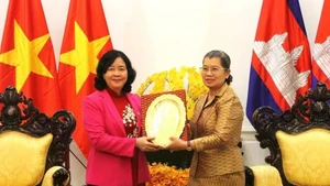 柬埔寨人民党（CPP）副主席、柬埔寨祖国发展团结阵线国家委员会主席梅森安向越南祖国阵线中央委员会主席裴氏明怀赠送纪念品。（图片来源：越通社）