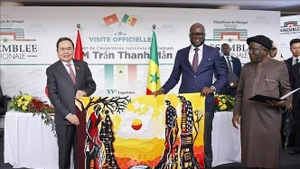 越南国会主席陈青敏与塞内加尔国民议会议长马利克·恩迪亚耶互赠礼品。（图片来源：越通社）