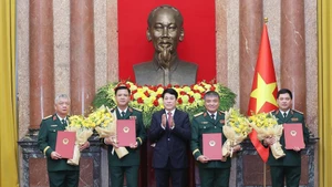 国家主席梁强向国防部副部长：阮鸿泰、阮文贤、阮长胜和越南人民军副总参谋长阮光玉等同志颁发中将晋升上将军衔的决定。（图片来源：越通社）
