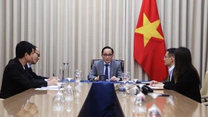 越共中央书记处书记、越南外交部代部长黎怀忠与英国内政大臣伊薇特·库珀通电话。（图片来源：《世界与越南》报）