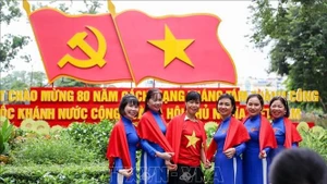 临近国庆，许多河内市民走上街头，与祖国红旗合影，以表达爱国之情和民族自豪感。（图片来源：越通社）