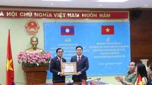 老挝人民革命党中央委员、色贡省委书记、省长列莱·西维莱向得乐省委书记阮廷忠颁授老挝政府一等劳动勋章。