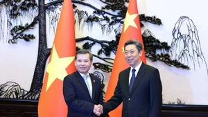 越南最高人民法院院长黎明智（左）与中共中央政法委书记陈文清。