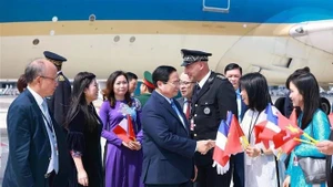 越南驻法国大使丁全胜及大使馆馆员热烈欢迎范明正总理一行。（图片来源：越通社）