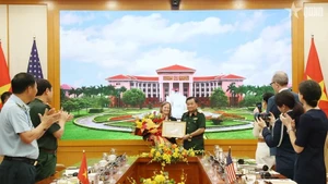 越共中央委员、中央军委常委、国防部副部长黄春战上将向美国国际开发署（USAID）驻越南首席代表阿勒·格拉布斯授予奖状。（图片来源：越通社）