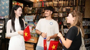 向国际游客赠送越南国旗。（图片来源：越通社）