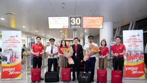 越捷航空领导与机组人员和乘客合影。（图片来源：越捷航空提供）