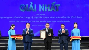 范明正总理和阮重义同志向《人民报》作者组代表颁发“民族崛起时代的文化外交”摄影类别一等奖。（图：世代）