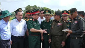 越南国防部副部长黄春战中将（左三）与柬埔寨皇家陆军副总司令伊萨拉将军（右二）讨论在柬埔寨柴桢省柴桢县建设桑索瓦纳小学友谊项目计划。（图片来源：越通社）