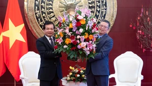 宋蓬·西加伦大使向范清平大使赠送花篮。