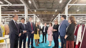 越南驻法国大使丁全胜与参加展览的越南企业代表交流。