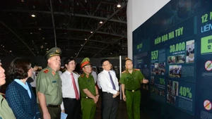 黎成龙副总理与各位代表参观有关打击毒品的展览。
