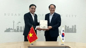 胡志明市人民委员会副主席阮禄河和韩国釜山市副市长李俊承。