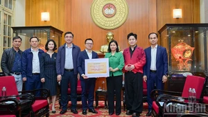 《人民报》社总编辑黎国明移交援助灾区同胞的善款。（宝龙 摄）