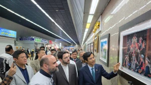 越南驻伊朗大使阮良玉向嘉宾介绍展出照片。（图片来源：越南驻伊朗大使馆）