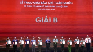 《人民报》社总编辑、越南新闻工作者协会主席黎国明与公安部副部长陈国祖上将向获得二等奖的作者和作者组代表颁奖。 （图片来源：越通社）