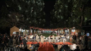 游客在户外音乐空间与乐队一起欣赏音乐。