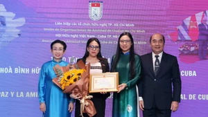 胡志明市友好组织联合会主席何清向古巴驻胡志明市总领事阿里亚德娜·费奥·拉布拉达颁授“致力于各民族和平友谊”的纪念章。