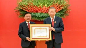 越共中央书记处常务书记陈锦秀向越共中央总书记苏林授予45年党龄纪念章。