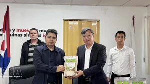 越南驻古巴大使黎光龙（右）向巴方代表象征性移交无偿援助大米。（图片来源：越通社）