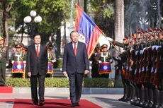 老挝人民革命党中央总书记、老挝国家主席通伦主持隆重仪式，欢迎越共中央总书记苏林一行到访。（图片来源：越通社）