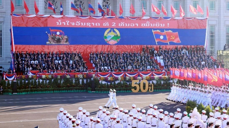 附图：纪念老挝国庆50周年的阅兵游行活动。（图片来源：越通社）