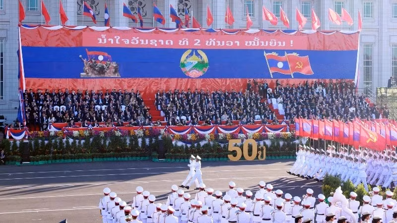 附图：纪念老挝国庆50周年的阅兵游行活动。（图片来源：越通社）