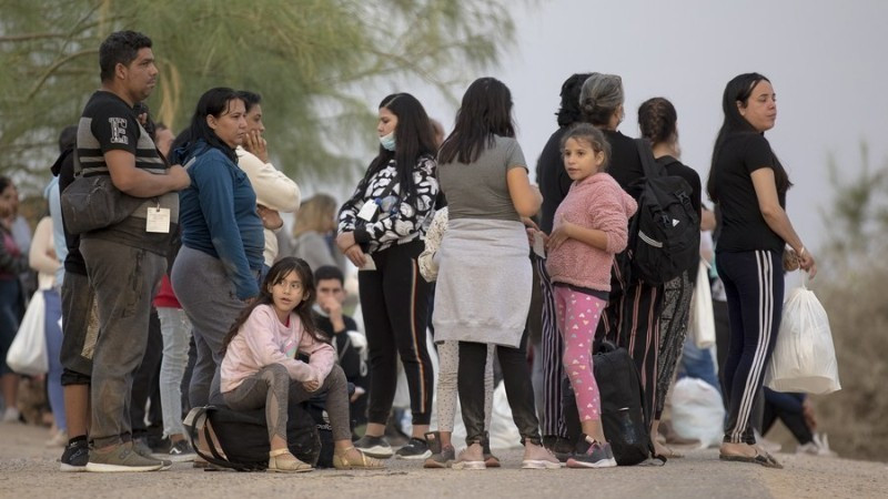 2022年10月10日，在美国德克萨斯州鹰关市的一个检查站，寻求庇护的移民等待登上巴士。（图片来源：新华社）