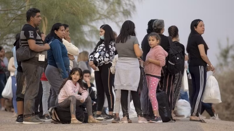 2022年10月10日，在美国德克萨斯州鹰关市的一个检查站，寻求庇护的移民等待登上巴士。（图片来源：新华社）