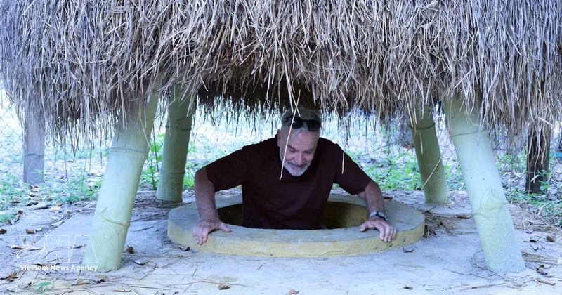 外国游客体验奇英地道当地居民院子里的地道口。（图片来源：越通社）